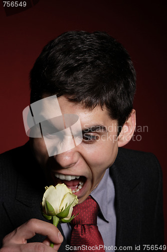 Image of  Young happy smiling handsome man with rose