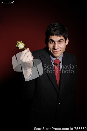 Image of  Young happy smiling handsome man with rose