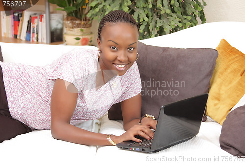 Image of Happy African American young woman using a laptop 