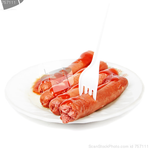 Image of Sausages dressed with ketchup and fork