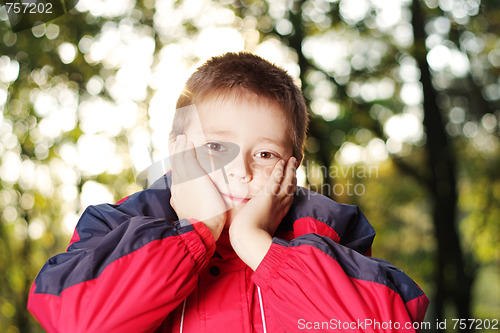 Image of Boy in forest hands at face