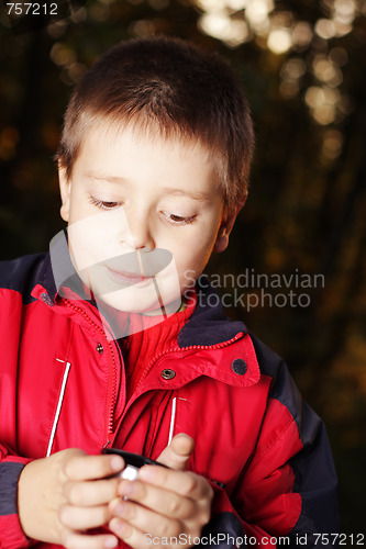 Image of Boy in dark forest holding cup