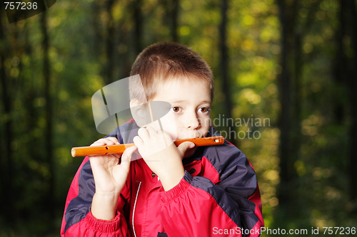 Image of Kid playing fluite in dark forest