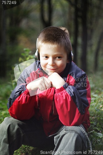 Image of Boy in dark forest listens music