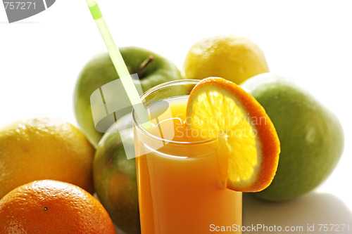 Image of Orange juice in glass in front of fruits