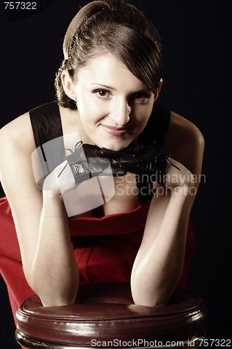 Image of Woman leaning on leather stool