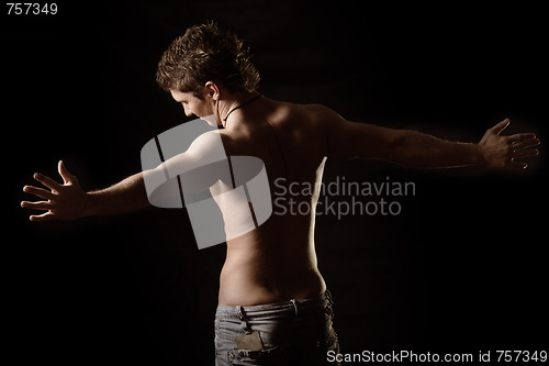 Image of Guy in jeans with arms raised