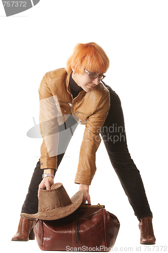 Image of Redhead traveler puts bag on ground