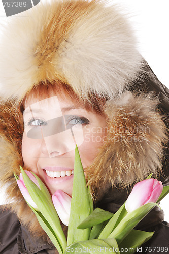 Image of Redhead in warm hood behind tulips