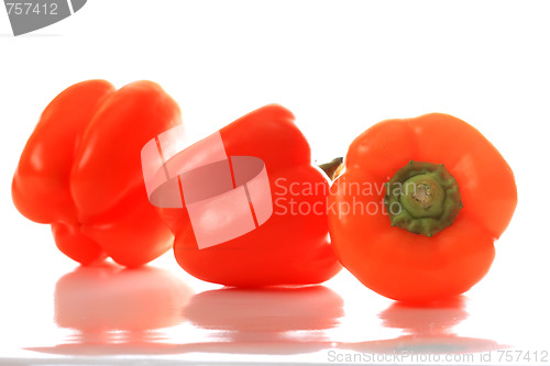 Image of Three orange paprikas with reflections