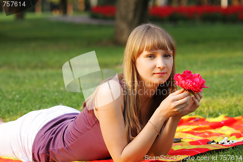 Image of Woman with red flower in park