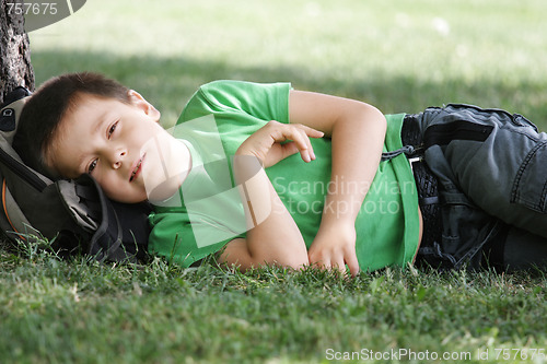Image of Boy laying down under tree