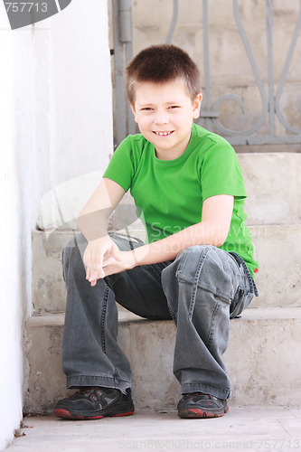 Image of Boy in green sitting on steps