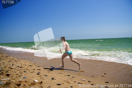 Image of Boy running along beach