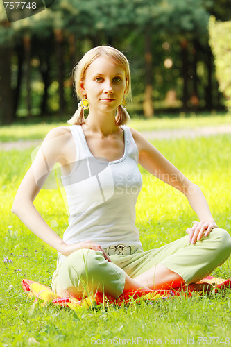 Image of Blonde in park legs crossed