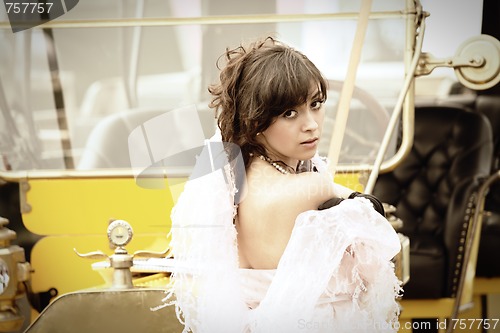 Image of Young woman and yellow retro car