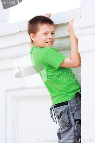 Image of Boy in green climbing on wall
