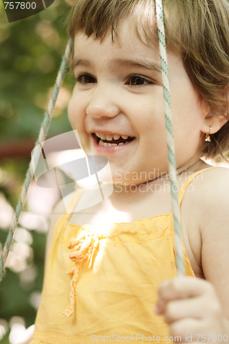 Image of Smiling girl in swings closeup