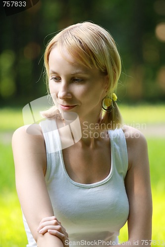 Image of Blonde in park lost in thoughts