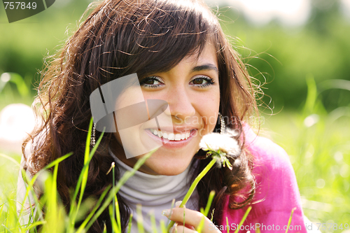 Image of Smiling brunette with dandelion