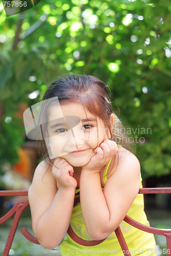 Image of Smiling girl leaning on fence