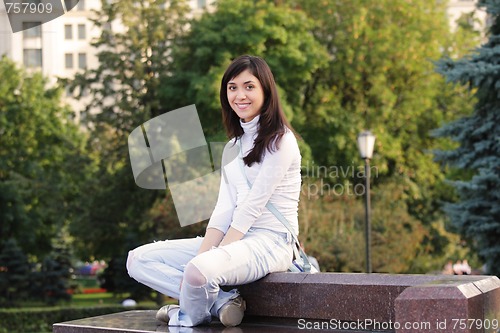 Image of Smiling girl sitting on stone bench