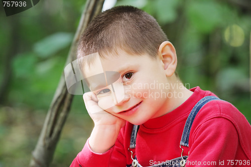 Image of Kid in forest leaning on hand