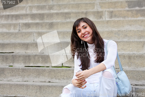 Image of Smiling brunette on stone steps