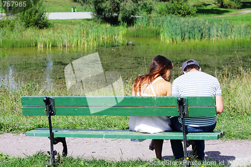 Image of Couple sitting at pond