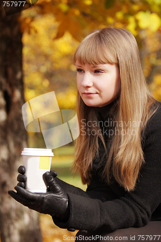 Image of Blonde in black coat with cup