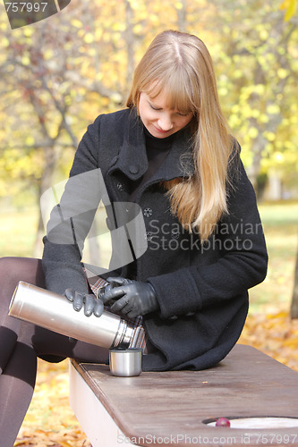 Image of Blonde with thermos and cup
