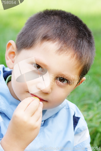 Image of Boy eats grape