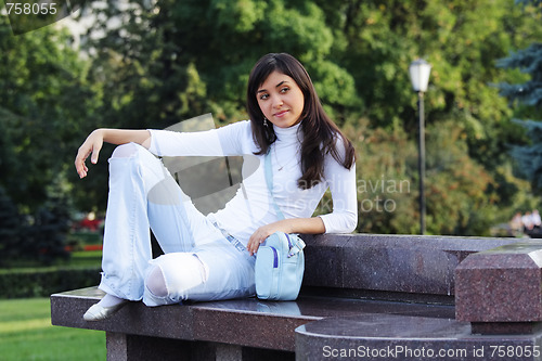 Image of Serene girl on stone bench