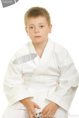 Image of Serious karate kid sitting on knees