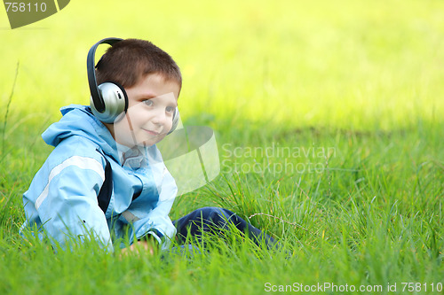 Image of Serene boy with headphones in meadow