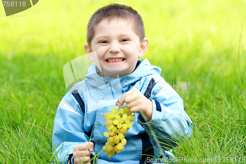 Image of Toothy smiling boy with grapes