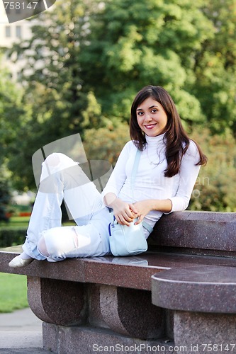 Image of Smiling girl on stone bench