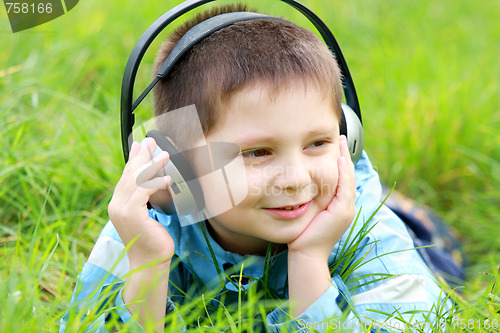 Image of Boy in grass enjoying music