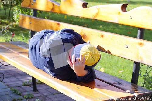 Image of Boy sleeping on bench