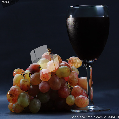 Image of Glass of red wine and grapes sideview
