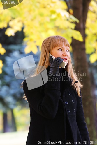 Image of Blonde walks and talks on phone