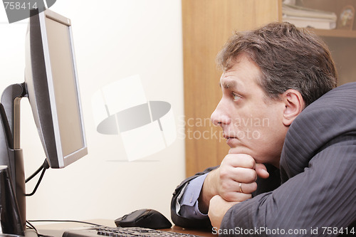 Image of Businessman looks to monitor