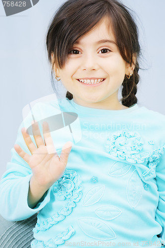 Image of Little girl raises hand in waving