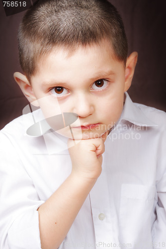 Image of Boy in white shirt leaning on fist