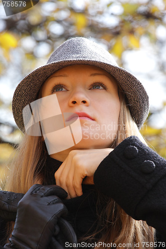 Image of Blonde in hat adjusting sweater