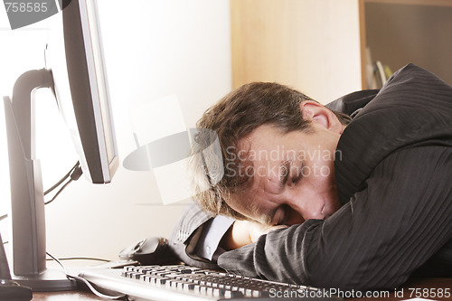 Image of Businesman sleeping on workplace