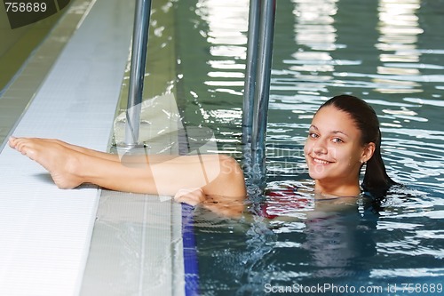 Image of Woman puts legs on pool edge