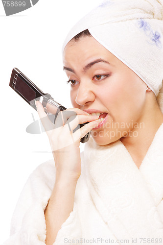 Image of Expressive woman in bathrobe with mobile