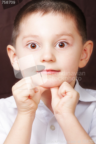 Image of Boy in white shirt leaning on thumbs