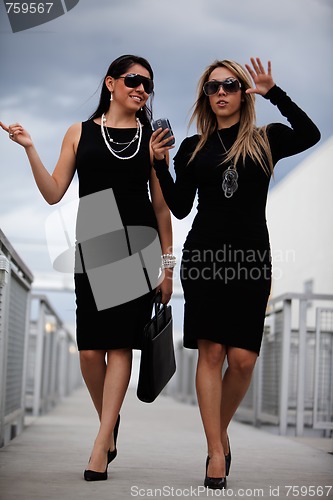 Image of Two attractive hispanic businesswomen walking outdoor 